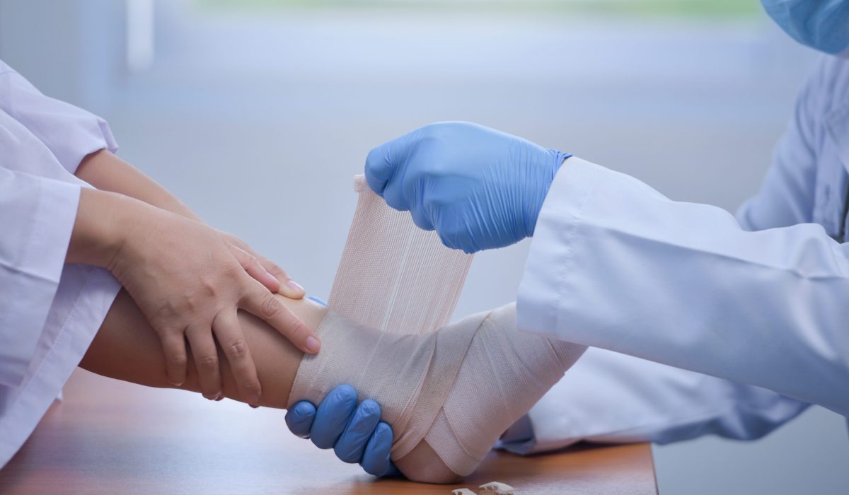 Feet holding with doctor,doctor analyzes and explains pain in the bones of the patient's feet.Doctor the traumatologist examines the leg examined at the medical office